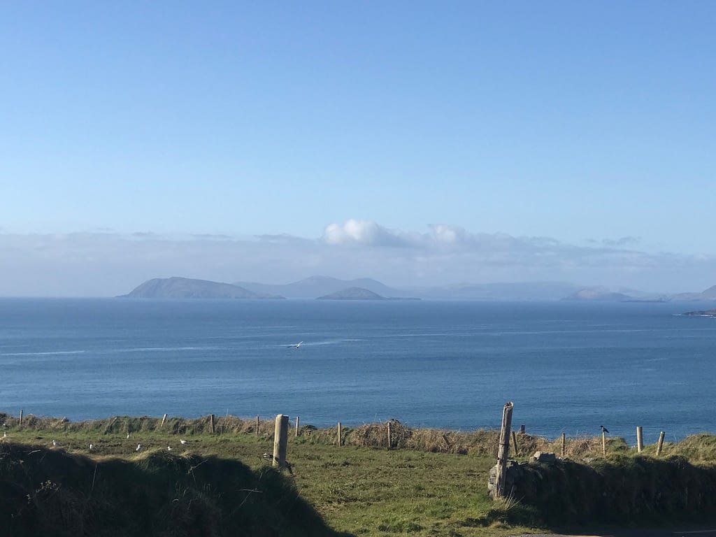 Gorgeous mountains and cliffs being the sea and a green field- in Cork Ireland